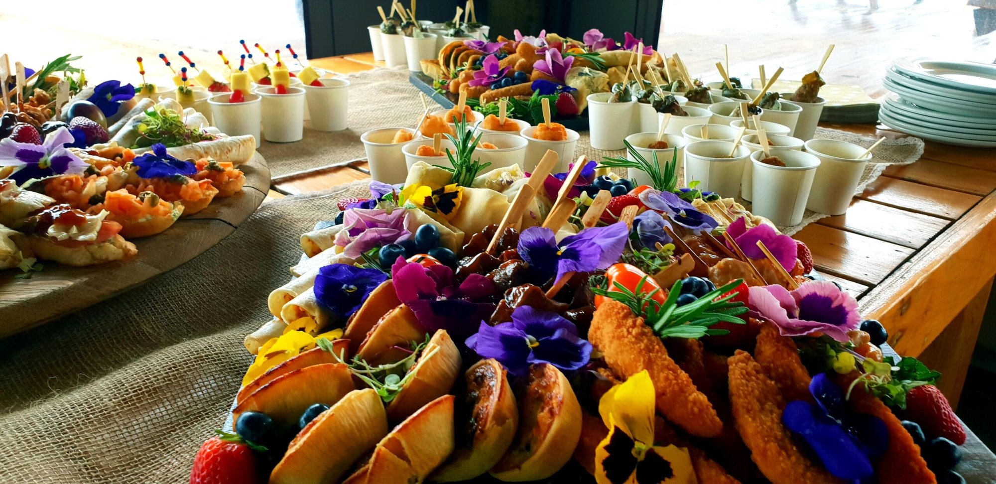 Vibrant assortment of food platters with flowers and fresh ingredients.
