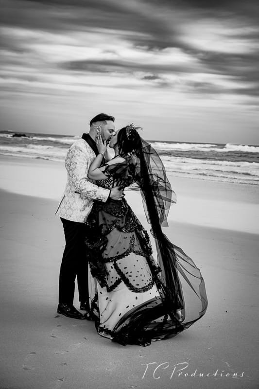 A couple kissing on the beach in black-and-white