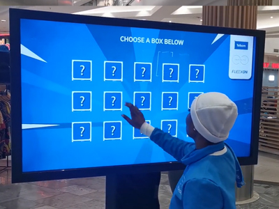 Person interacting with a large touchscreen display in a venue