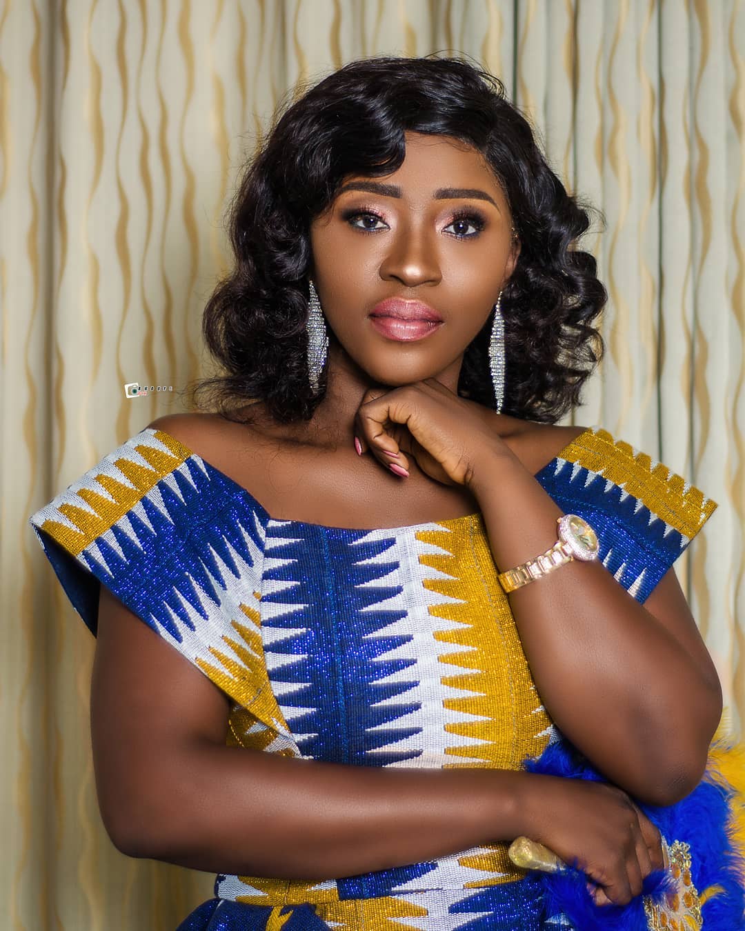 A well-dressed woman posing elegantly for a portrait.