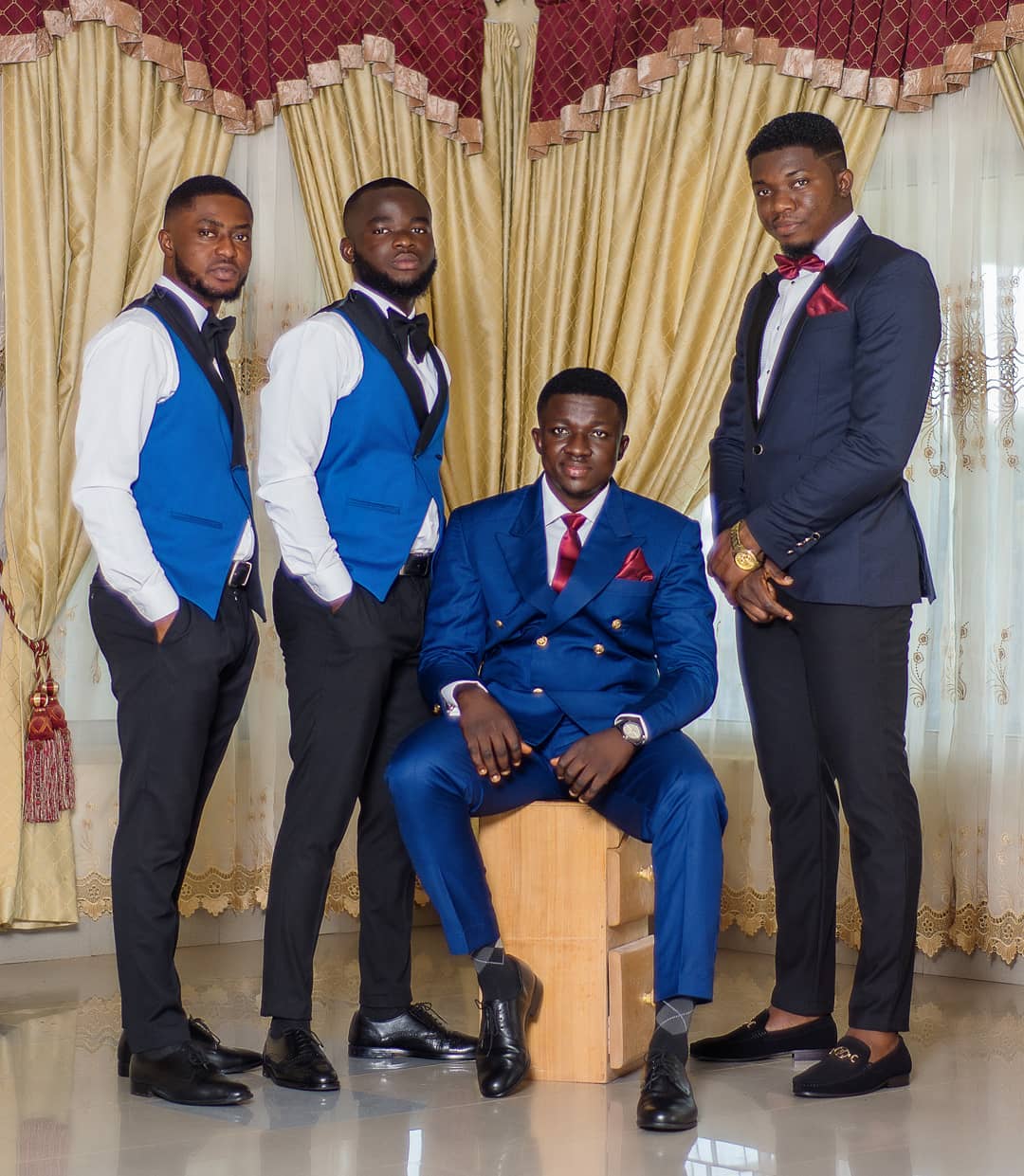 Group of four well-dressed men posing indoors