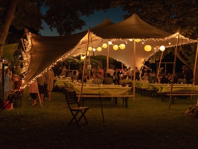 Outdoor Bedouin tent with string lights and guests dining.