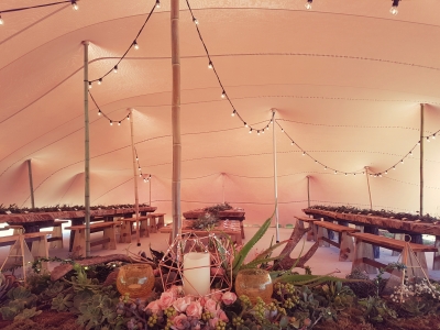 Inside of a Bedouin tent with tables, flowers, and lights