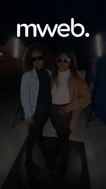 Two women posing at a 360 photo booth