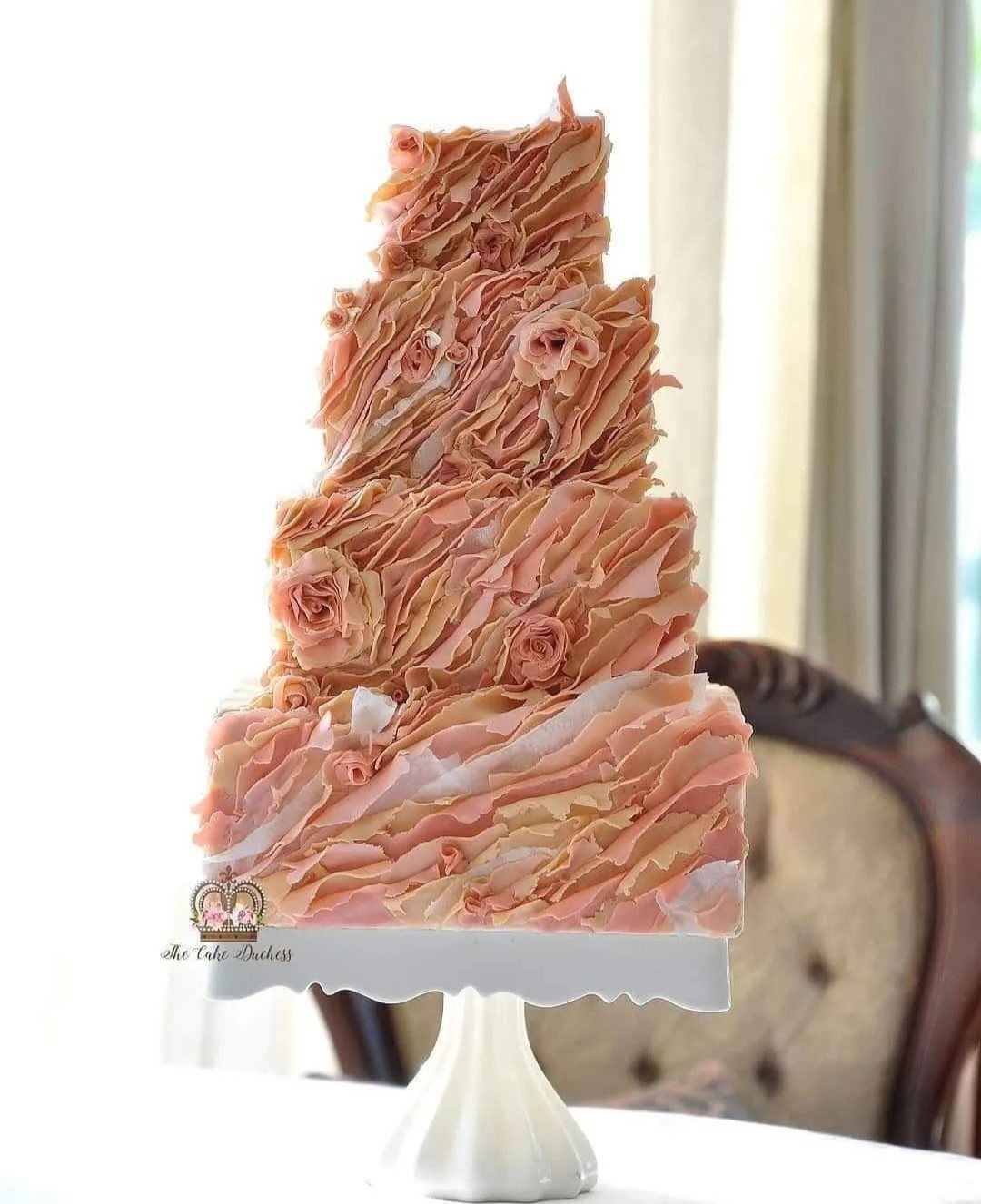Three-tiered fondant wedding cake with ruffles and roses