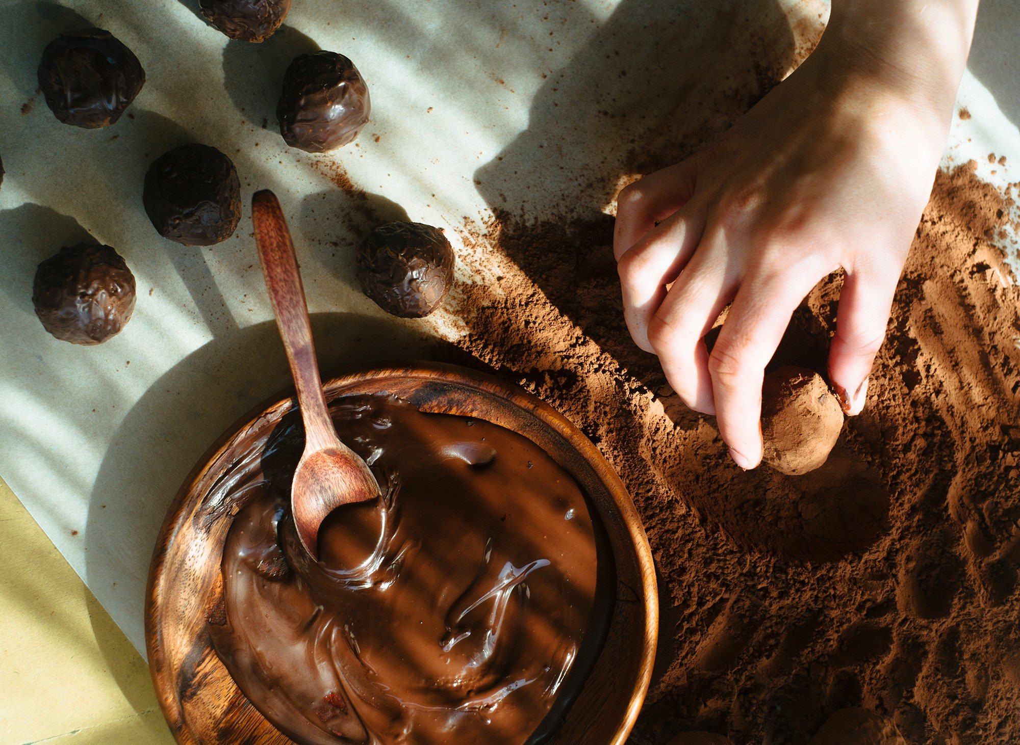 Hand rolling chocolate truffles in cocoa powder