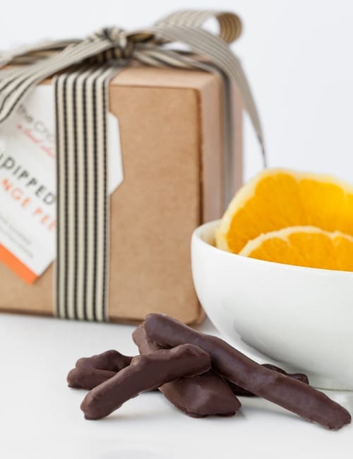 Chocolate-dipped orange peels in a stylish box and bowl.