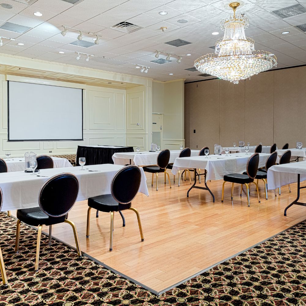 Conference room with tables, chairs, and a projector screen