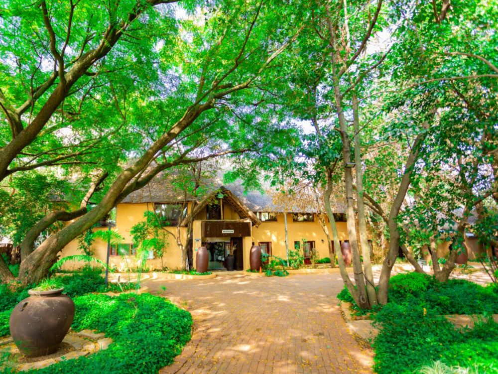 The entrance of The Garden Venue, framed by trees and greenery.