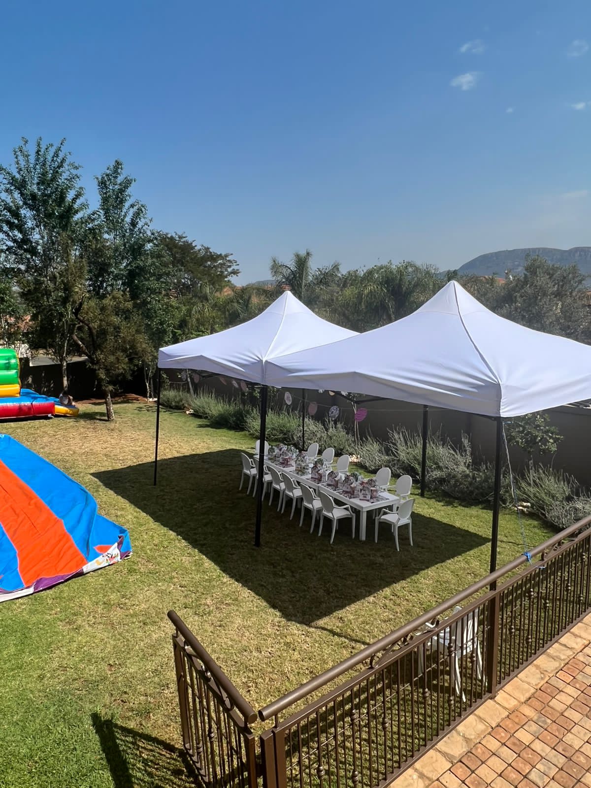 Two white gazebos set up in a garden for a party