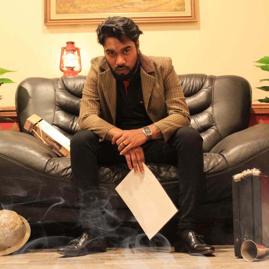 A man seated in a themed escape room setup.