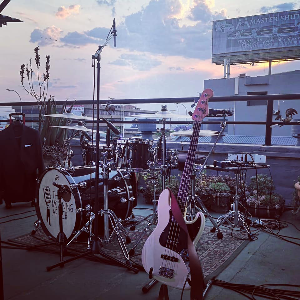 Drum kit and bass guitar at an outdoor event setup.