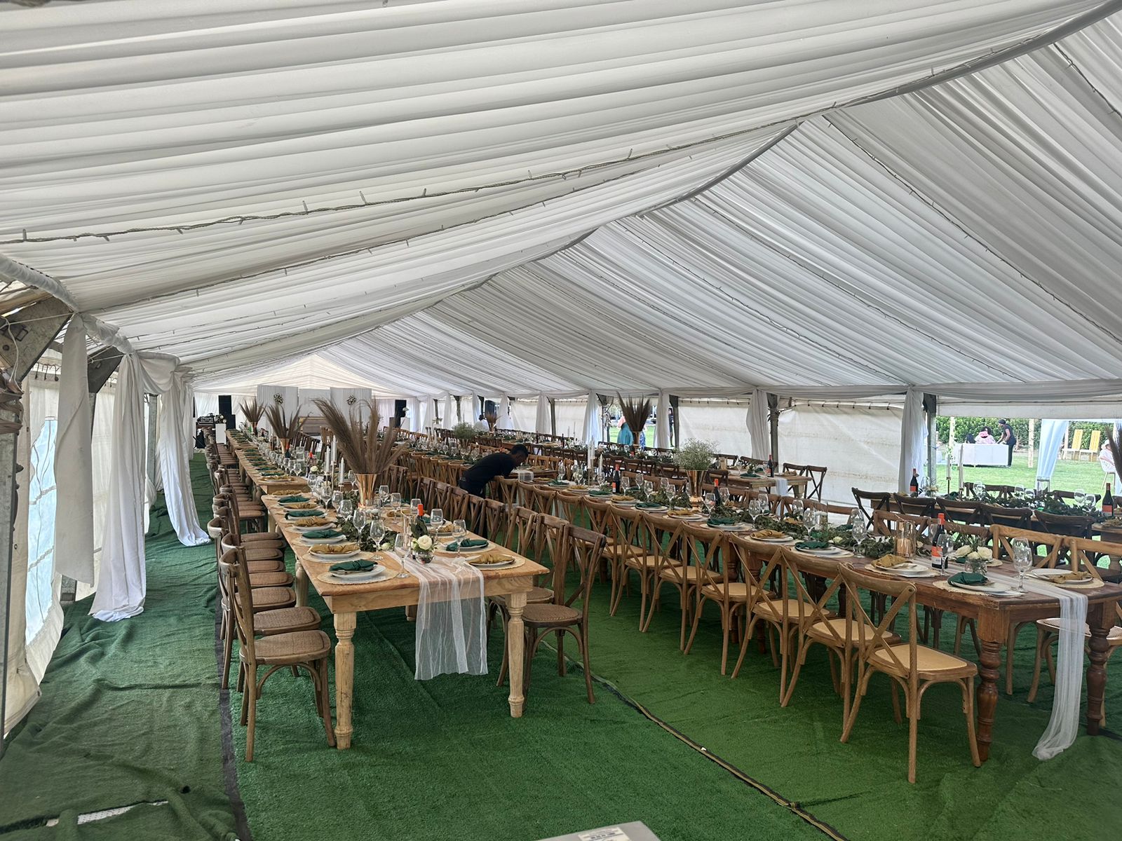 Elegant dining setup in a marquee with long tables.