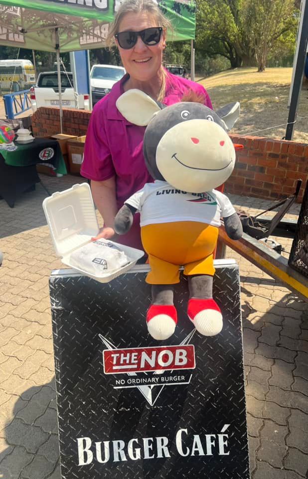 Staff member with a plush mascot at The Nob Burger Cafe
