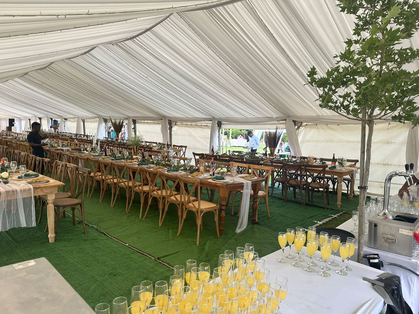 Interior of a decorated event tent with tables and drinks