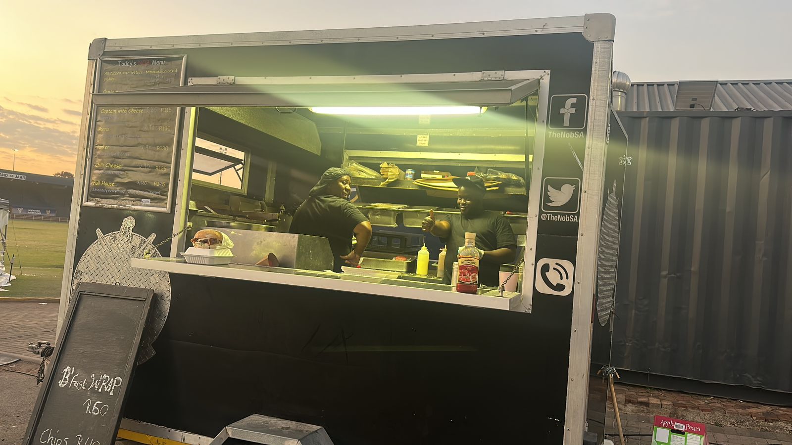 Food truck with staff preparing burgers inside.