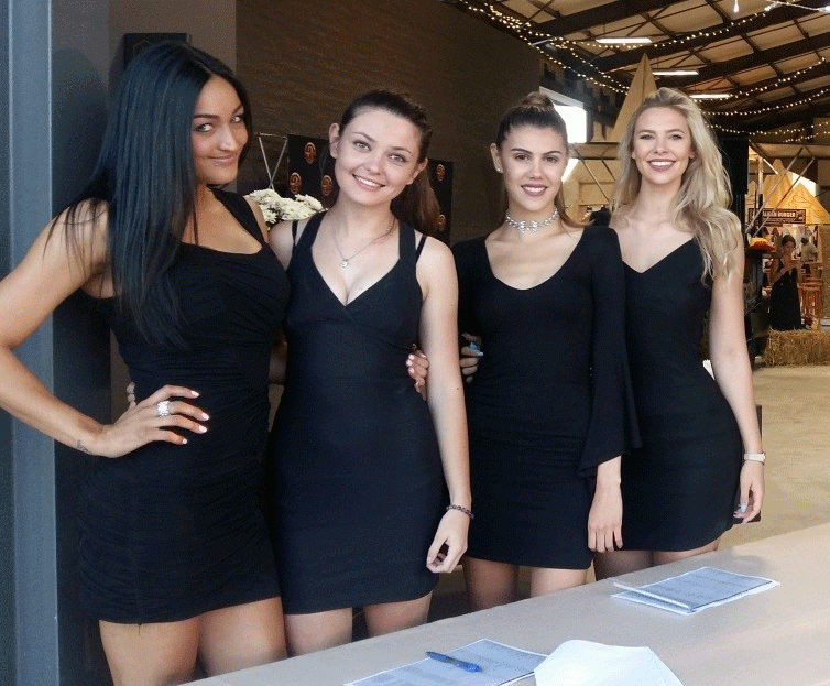 Four professional staff members in black dresses at an event