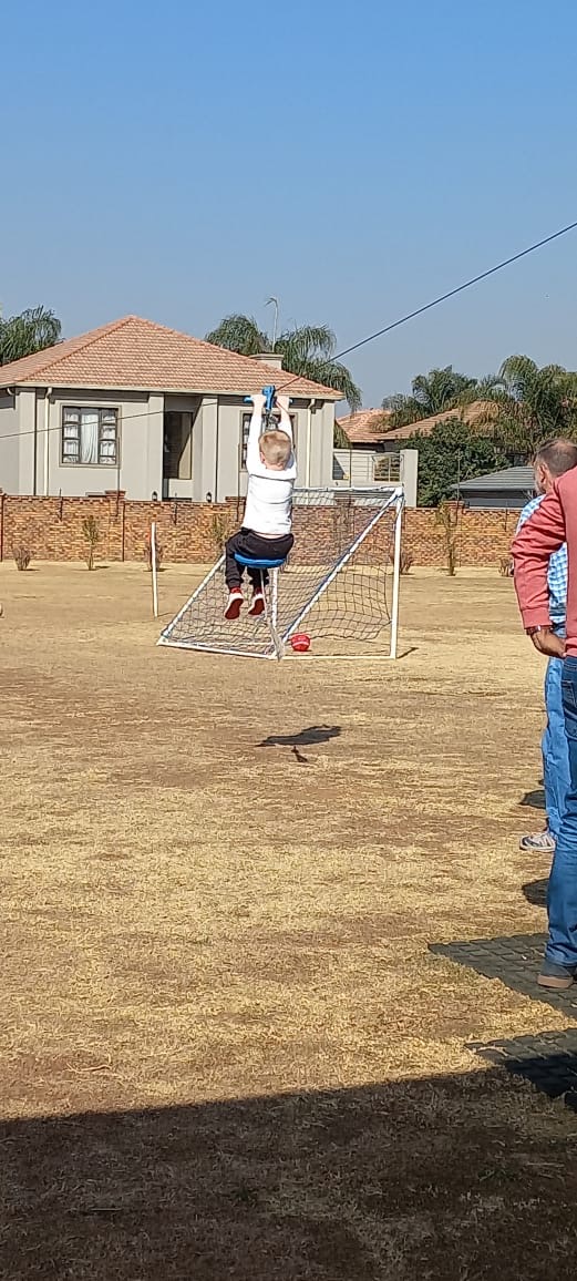Child hanging from a soccer goal at The Party Park