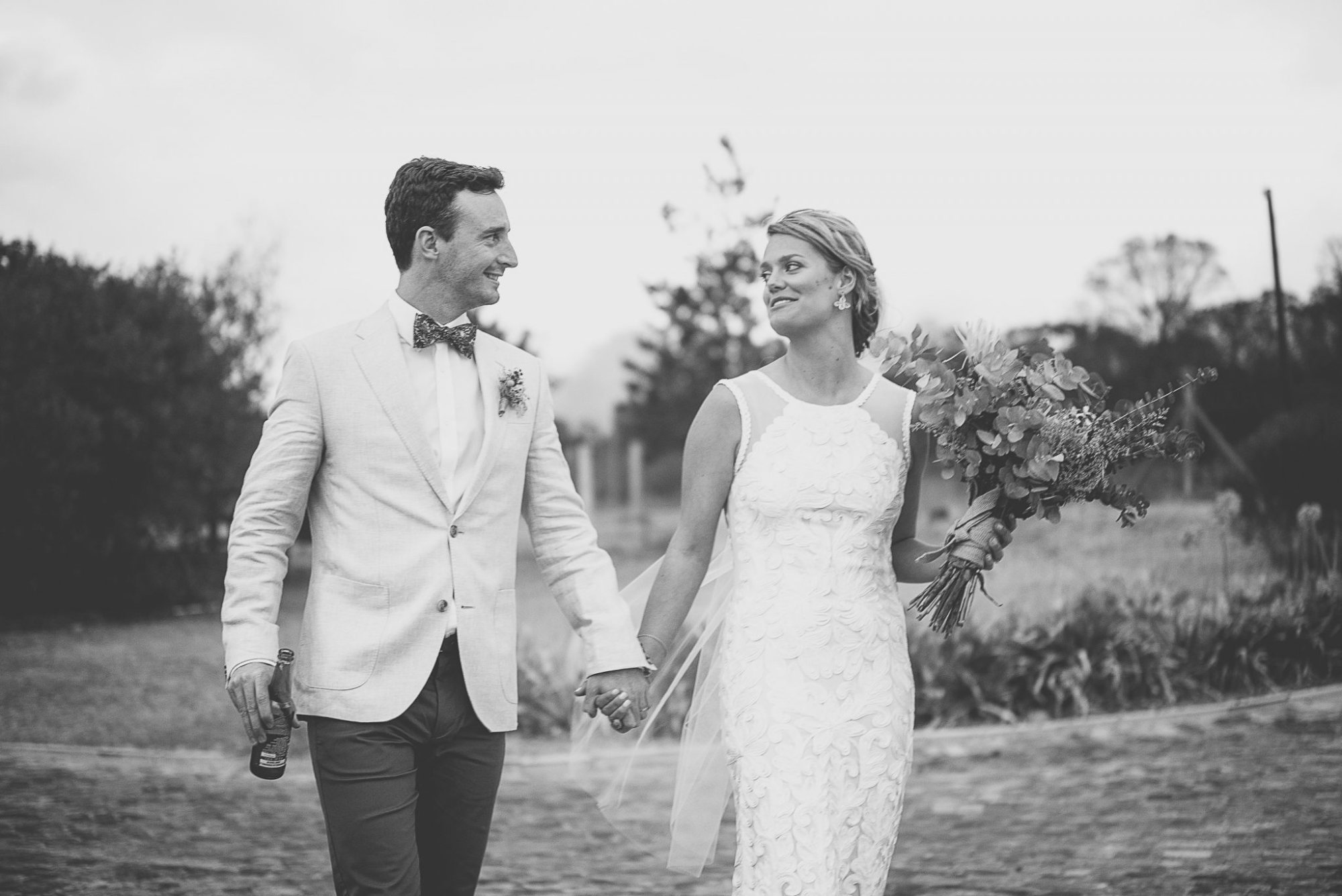 Black and white image of a couple walking hand in hand