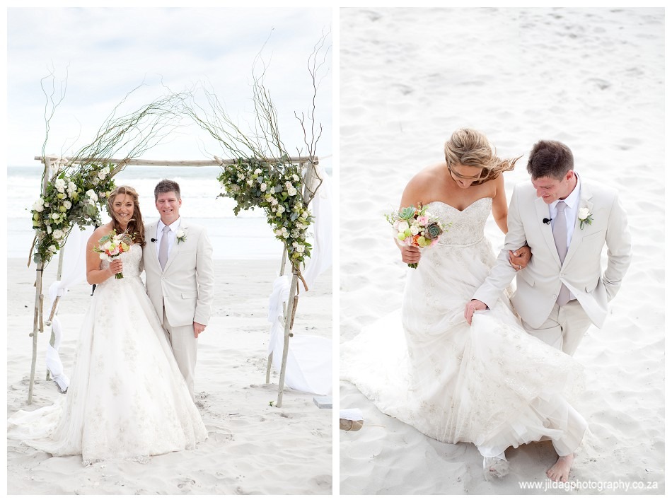 Beach proposal setup with floral decor and a couple in wedding attire.