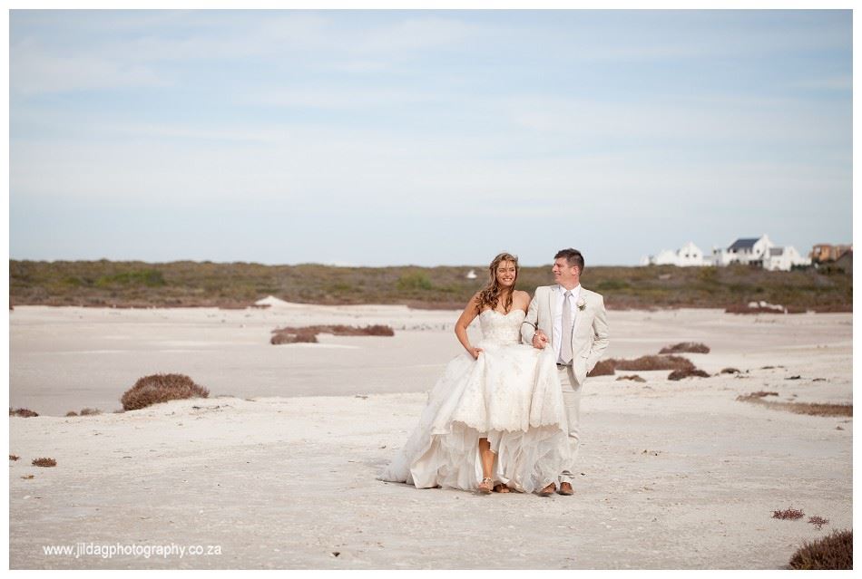 Couple walking on a beach in wedding attire