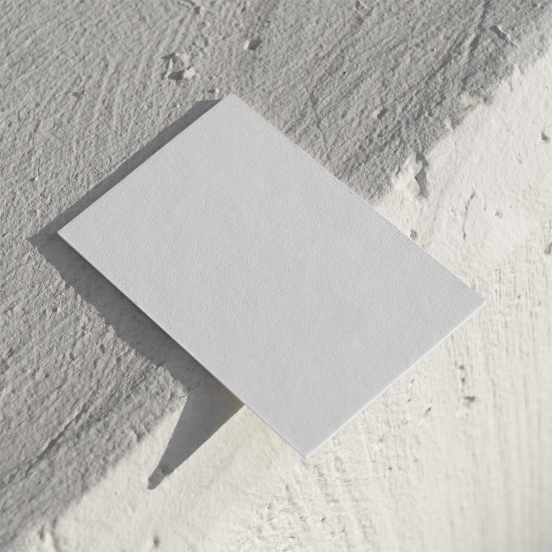 Blank white invitation card on a textured surface