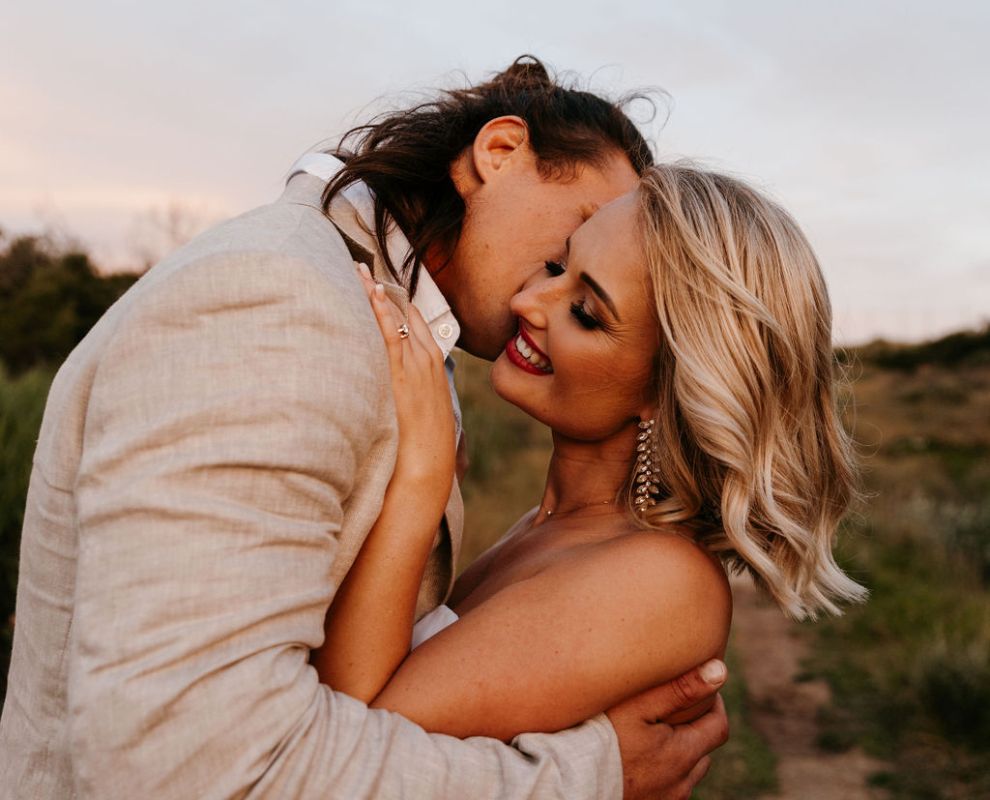 A couple embracing outdoors at sunset.