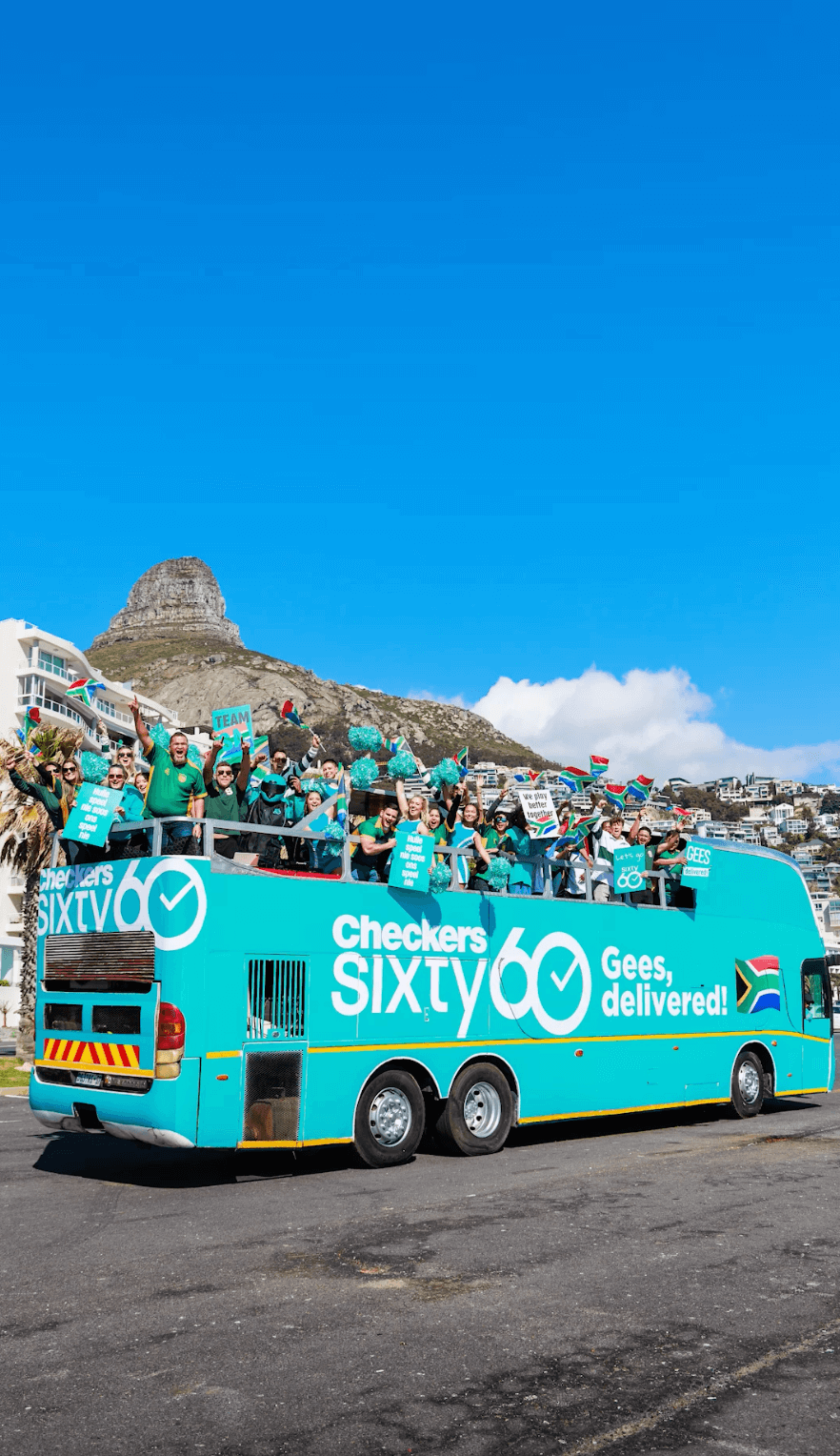 A colorful open-top party bus with a group celebrating onboard