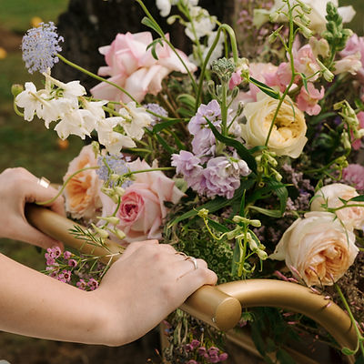Hands holding a cart with various fresh flowers