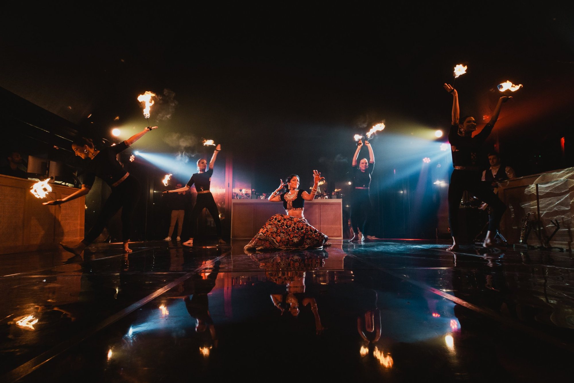 Dance performance with fire and reflections on the floor
