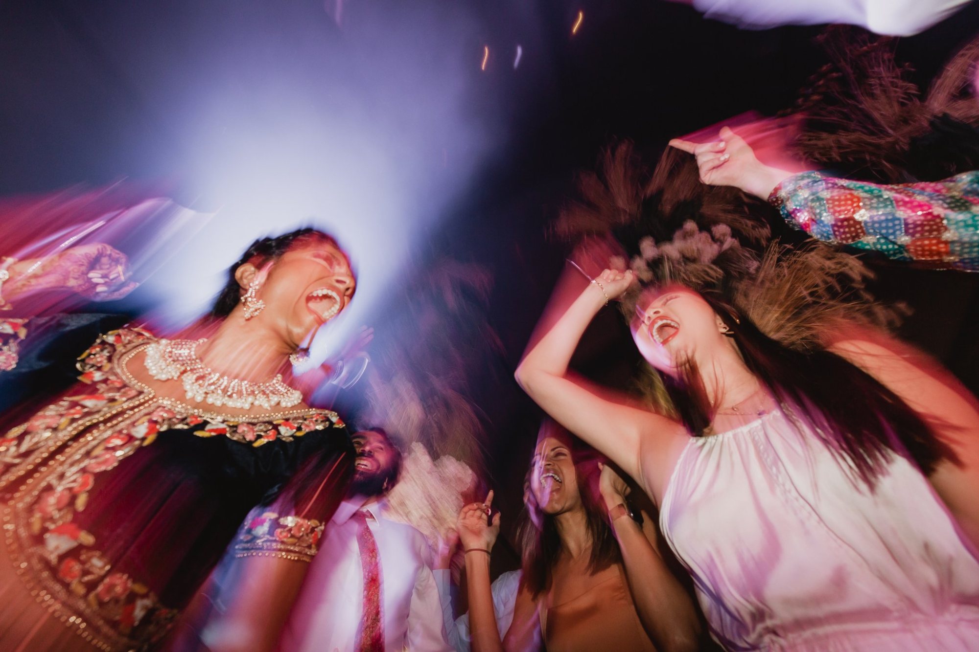 Guests dancing energetically on a vibrant dance floor