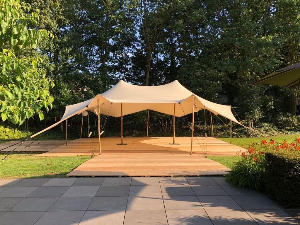Bedouin-style marquee on wooden floor in a garden