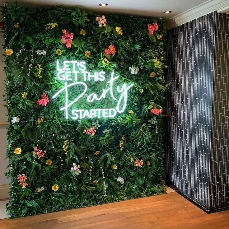 Floral wall with neon text saying 'Let's get this Party Started'.