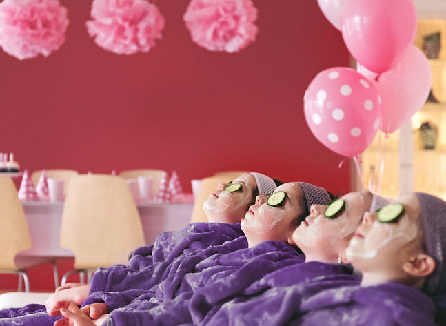 Children enjoying a pampering session with cucumbers on their eyes
