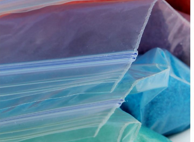 Close-up of colorful sand in resealable bags