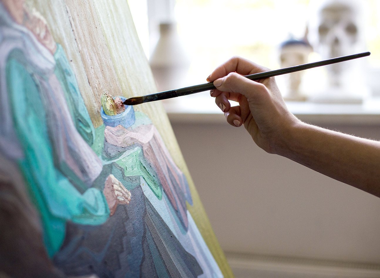 A hand painting on a canvas with vibrant colors.