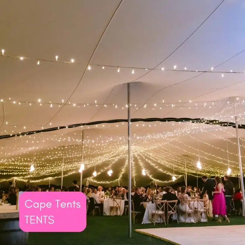 Interior of a decorated tent with fairy lights and dining tables.