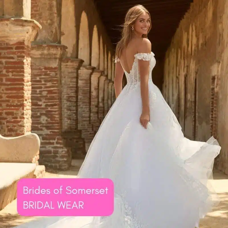 Bride in off-the-shoulder gown in a stone archway