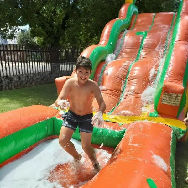 Child playing on an inflatable water slide