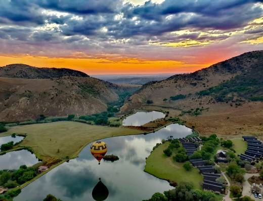 Hot air balloon above a lake during sunset