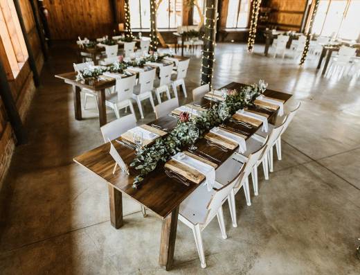 Rustic tables decorated with greenery in a reception area