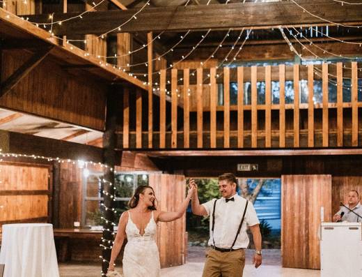 Couple celebrating in a rustic venue with string lights.