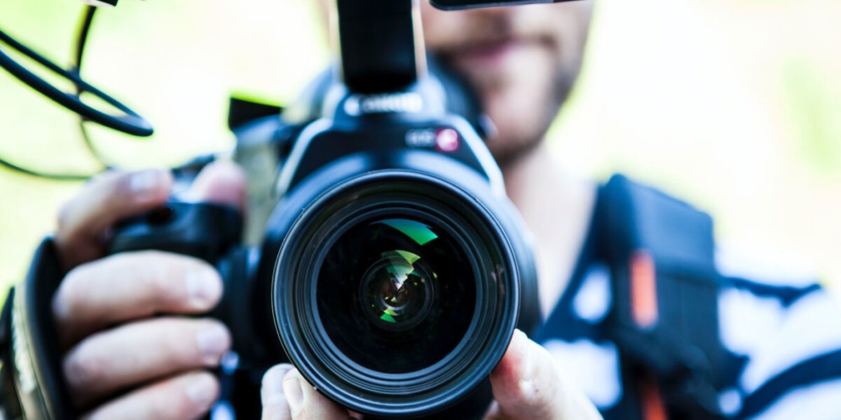 Videographer holding a professional video camera.