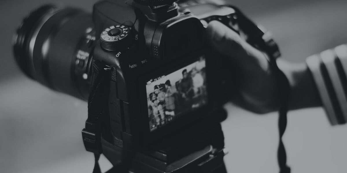 Close-up of a professional camera with a display showing images.