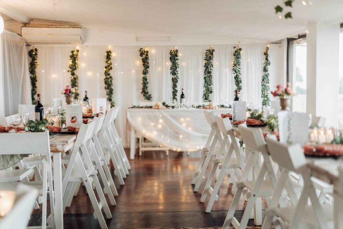 Reception area with white tables, floral decor, and soft lighting