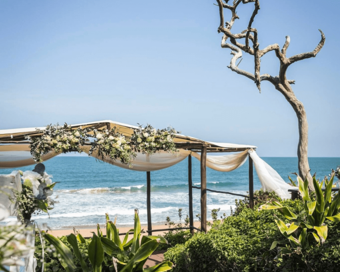 Beach ceremony deck with draped fabric and ocean view