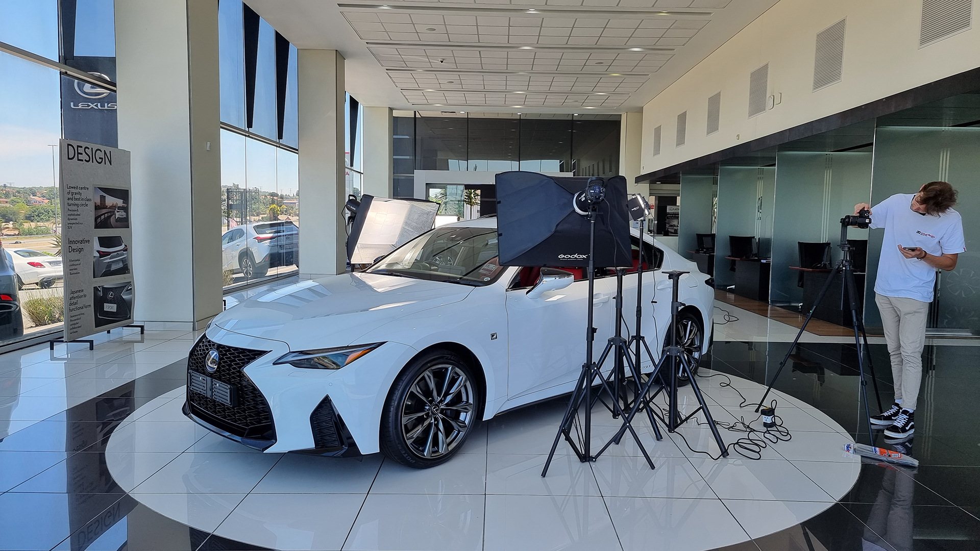 A Lexus vehicle with studio lighting and a photographer at work.