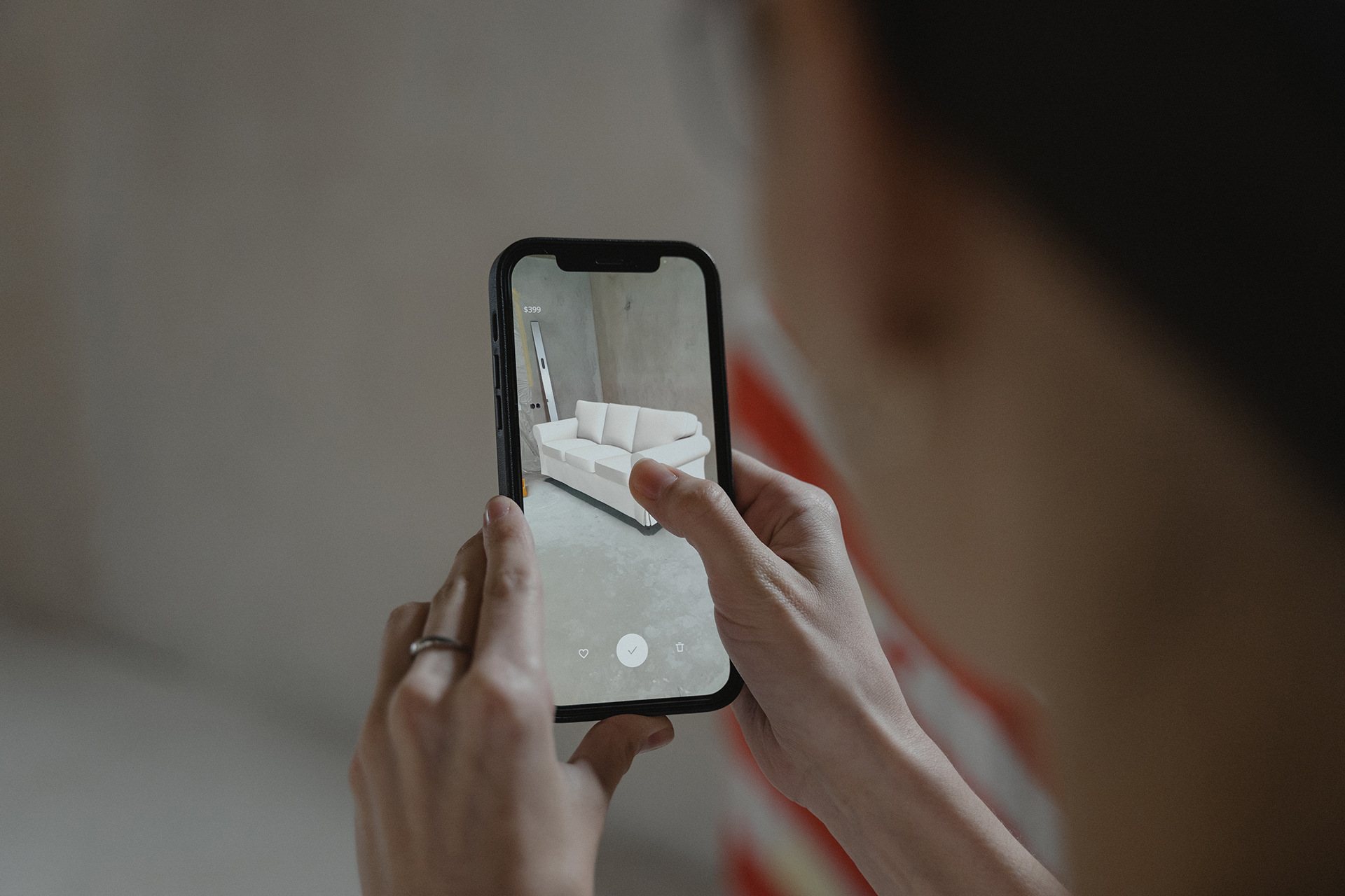Person using a phone to capture a VR couch setup