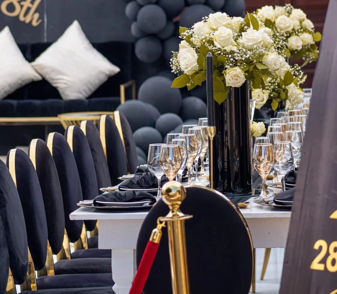 Elegant dining table with black chairs and floral centerpiece.