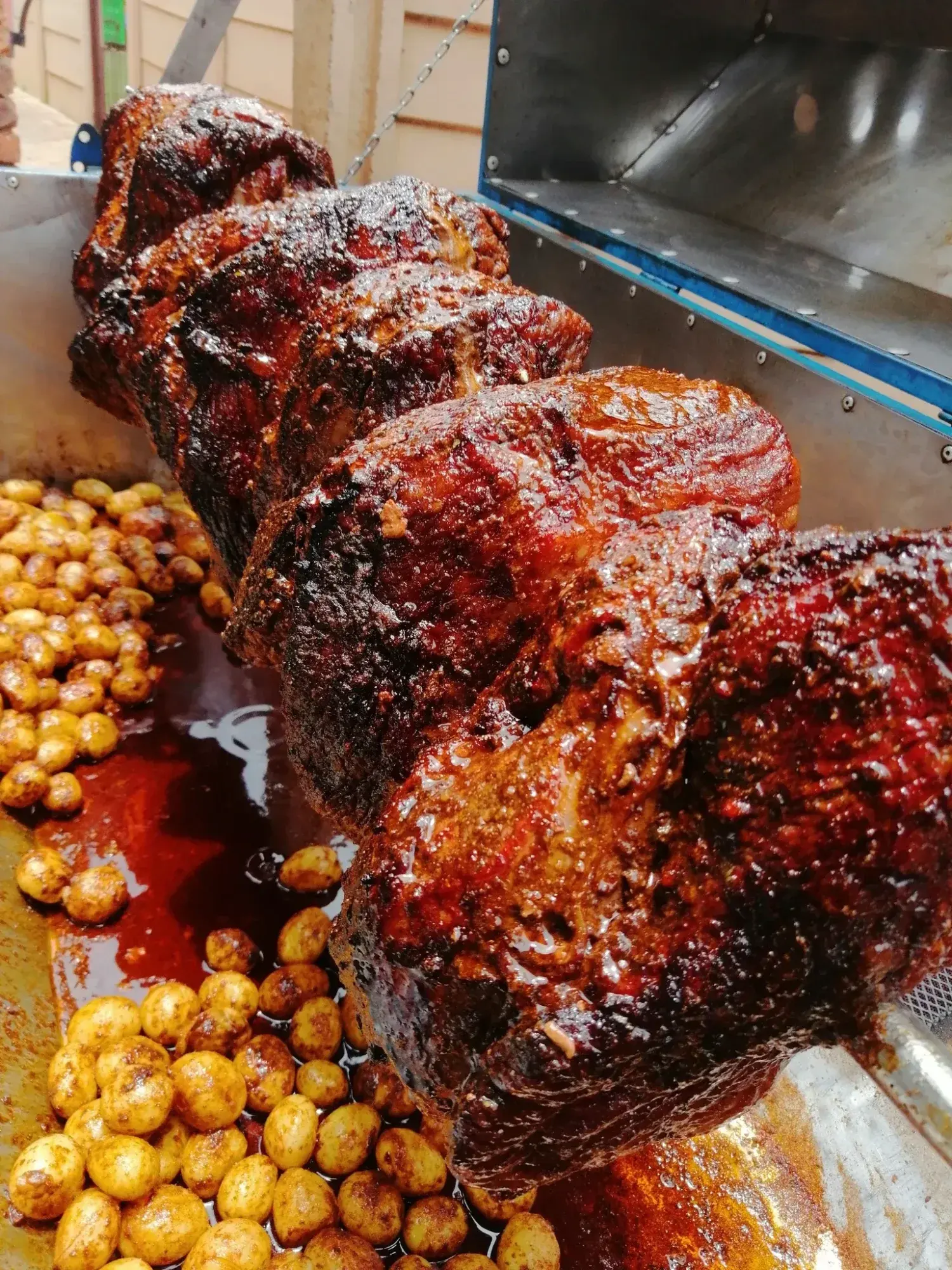 Slow-roasted meat on a spit with golden potatoes